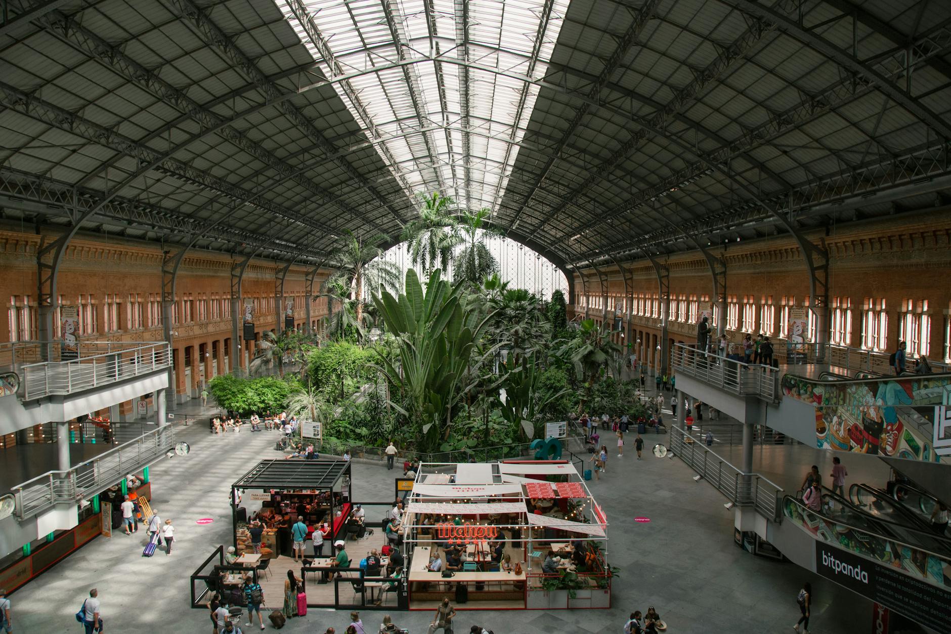 Busy train station with a botanical garden in the center