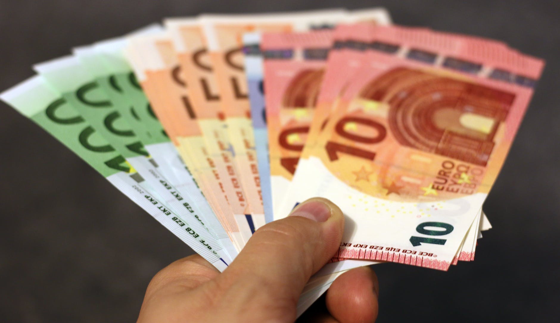A person holding a handful of euros 