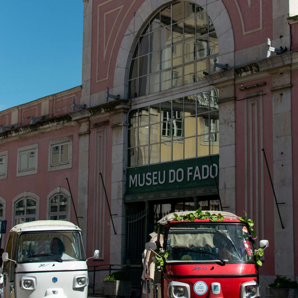 Two small cars in front of a pink museum