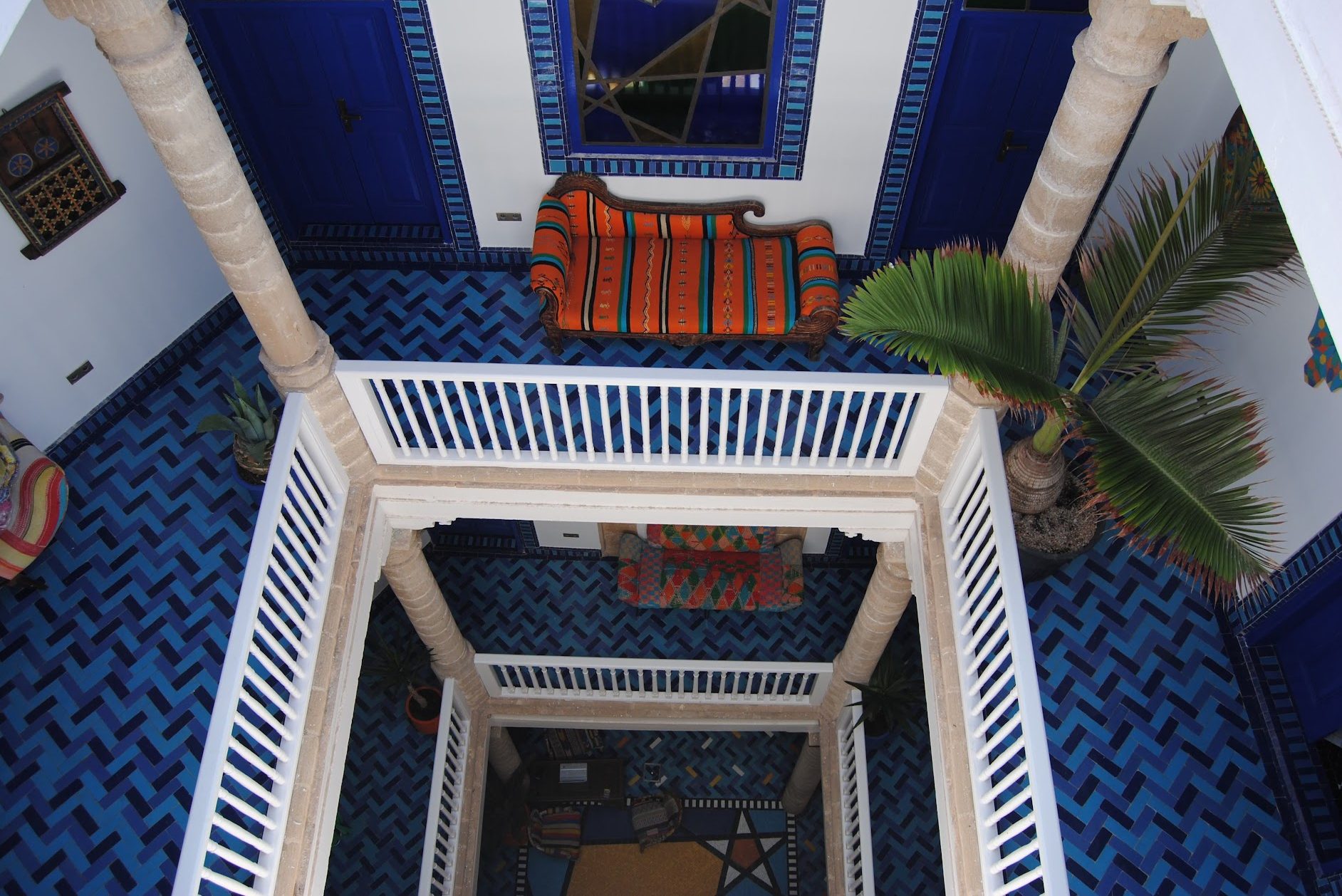 The inside of a multi-storied courtyard of a blue riad